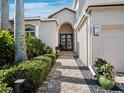 Charming front entrance with a paved walkway, manicured hedges, and a beautifully landscaped yard at 2065 Harbour Links Dr # 5, Longboat Key, FL 34228