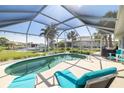 Screened in pool and patio area features lounge chairs, landscaping, and a view of the canal and boat dock at 2501 W Marion Ave, Punta Gorda, FL 33950