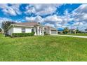 A well maintained single-story home with a two car garage and green lawn at 26052 Salonika Ln, Punta Gorda, FL 33983