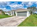 A well maintained single-story home with a two car garage and green lawn at 26052 Salonika Ln, Punta Gorda, FL 33983