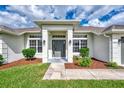 Inviting home entrance with manicured landscaping and a covered entryway at 26052 Salonika Ln, Punta Gorda, FL 33983