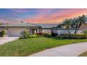 Charming home featuring lush landscaping, attached garage, and well manicured lawn at 3445 Highlands Bridge Rd, Sarasota, FL 34235