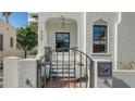Welcoming entrance with gated stairs, a black-framed door, and charming wall mounted mailbox at 422 Burns Ct, Sarasota, FL 34236