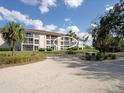Exterior of a three-story condo building featuring private balconies and lush landscaping at 6501 Stone River Rd # 205, Bradenton, FL 34203