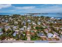 Wide aerial view of a waterside neighborhood with tropical landscaping and clear ocean waters at 691 Linley St, Longboat Key, FL 34228