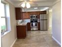 A kitchen featuring stainless steel appliances and brown wooden cabinets at 1290 Drury Ln, Englewood, FL 34224