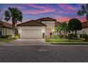 Charming home showcasing a tiled roof, stone accents, well-maintained landscaping, and inviting two-car garage at 13038 Prima Dr, Bradenton, FL 34211