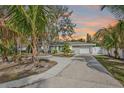 Charming single-story home with a well-manicured lawn, mature trees, and a long concrete driveway at 1409 2Nd E Ave, Bradenton, FL 34208