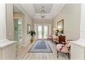 Bright foyer with a decorative rug, chandelier, and view of the home's interior at 15209 Montello Way, Bradenton, FL 34211