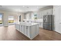 Gourmet kitchen with stainless steel appliances, a large center island, and light gray cabinets at 16435 Umbria Pl, Bradenton, FL 34211