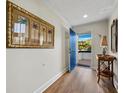 Light and airy entryway with blue door and coastal-themed art at 2012 Harbourside Dr # 2104, Longboat Key, FL 34228