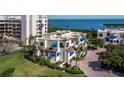 Condo with blue awnings, tropical foliage, and coastal views at 2012 Harbourside Dr # 2104, Longboat Key, FL 34228