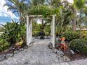 Outdoor garden area featuring an arbor, gravel pathway, and whimsical animal statuary at 333 Bayshore Dr, Venice, FL 34285