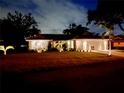 Charming single-story home featuring a well-manicured front lawn and beautiful tropical landscaping at twilight at 3610 Garden Lakes Clenet, Bradenton, FL 34203