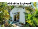 Charming backyard studio featuring sliding glass doors, surrounded by lush, tropical landscaping at 4062 S Shade Ave, Sarasota, FL 34231