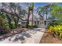Charming single-story home with mature landscaping and a long driveway at 4062 S Shade Ave, Sarasota, FL 34231
