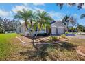 Attractive single story home with a well manicured lawn, tropical palms, and a three car garage at 4110 Noble Pl, Parrish, FL 34219