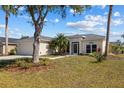Single-story home with two-car garage, well-manicured lawn, and lovely landscaping at 4202 Donnington Dr, Parrish, FL 34219