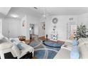 Bright living room with wood floors, white sofas, blue pillows, and a modern rug at 4202 Donnington Dr, Parrish, FL 34219