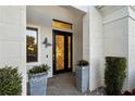 Elegant front entrance with a decorative door, manicured plants, and a butterfly ornament at 5074 Surfside Cir, Bradenton, FL 34211