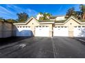 View of multi-unit garages with white doors and a green roof for secure parking at 5122 Northridge Rd # 110, Sarasota, FL 34238