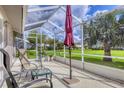 Relaxing screened lanai with patio furniture, offering peaceful outdoor living space with verdant view at 5320 Crestlake Blvd # 26, Sarasota, FL 34233