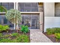 Ground floor condo patio with screened enclosure, outdoor seating, and manicured garden area at 5710 Palmer Cir # 105, Bradenton, FL 34211
