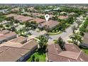 Aerial view of a home with a brown tiled roof surrounded by palm trees and manicured lawns at 5907 Guarino Dr, Sarasota, FL 34238