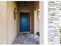 The elegant entrance to the home boasts a blue door with glass panels and stone detailing on the facade at 11679 Renaissance Blvd, Venice, FL 34293