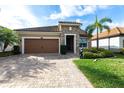 Charming single-story home with a brick driveway, two car garage and landscaped yard at 11679 Renaissance Blvd, Venice, FL 34293