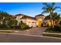 Beautifully landscaped home features a paver driveway and lush tropical landscaping with a barrel tile roof at 15520 Castle Park Ter, Lakewood Ranch, FL 34202