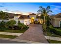 Beautifully landscaped home features a paver driveway and lush tropical landscaping with a barrel tile roof at 15520 Castle Park Ter, Lakewood Ranch, FL 34202
