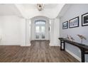 Bright foyer with wood-look tile flooring, soaring ceilings, arched doorways, and natural light at 15520 Castle Park Ter, Lakewood Ranch, FL 34202