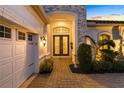 Stunning front entrance with double doors, stone accents, and a paver walkway, adjacent to the garage at 15520 Castle Park Ter, Lakewood Ranch, FL 34202