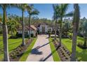 Stately white exterior elevation featuring manicured landscaping and a paver driveway lined with tall palms at 19424 Ganton Ave, Lakewood Ranch, FL 34202