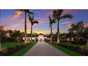 Inviting exterior view of a home with a meticulously landscaped front yard and stately palm trees against a sunset sky at 19424 Ganton Ave, Lakewood Ranch, FL 34202