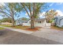Street view of cozy home with trees, white fence, and well-maintained front yard at 3457 50Th N Ave, St Petersburg, FL 33714