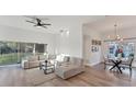 Open-concept living and dining room with modern decor, light wood flooring, and ample natural light from large windows at 4414 Turnberry Ct, Bradenton, FL 34210