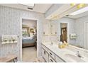 Well-lit bathroom with double sinks, and a doorway leading to the bedroom at 534 Warwick Ln, Venice, FL 34293