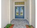 Stylish entryway with blue double doors and stone-paved walkway at 552 Bocelli Dr, North Venice, FL 34275