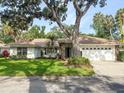Inviting home with lush landscaping, a driveway leading to a two-car garage, and a classic tile roof at 5708 Garden Lakes Fern, Bradenton, FL 34203