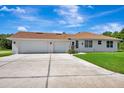 Spacious three-car garage with a concrete driveway and manicured lawn at 5750 Saddle Oak Trl, Sarasota, FL 34241