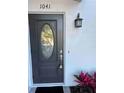 This home features an elegant front door with decorative glass and a stylish outdoor lantern, offering a welcoming entrance at 1041 S Tuttle Ave, Sarasota, FL 34237