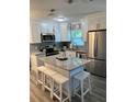 Bright kitchen with a center island, granite countertops, stainless steel appliances, and white cabinets at 1041 S Tuttle Ave, Sarasota, FL 34237