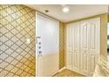 Condo entryway with patterned wallpaper, a closet, and tile flooring at 1125 W Peppertree Dr # 706, Sarasota, FL 34242