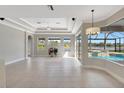 Bright living room featuring tile floors, recessed lighting, tray ceilings, and expansive windows with pool view at 11254 Rivers Bluff Cir, Lakewood Ranch, FL 34202