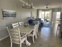 This dining area showcases a charming table for six, flowing into a naturally lit living room with outdoor access at 12229 Amica Loop, Venice, FL 34293