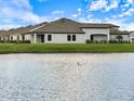 Back of house with a view of a lake and expansive lawn at 12518 Oak Hill Way, Parrish, FL 34219