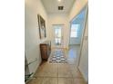 Inviting tiled entryway featuring a decorative front door, a console table and an adjacent room at 13602 Abercrombie Dr, Englewood, FL 34223