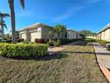 Low angle, sunny day showcases the landscaping around the side of the villa at 13602 Abercrombie Dr, Englewood, FL 34223